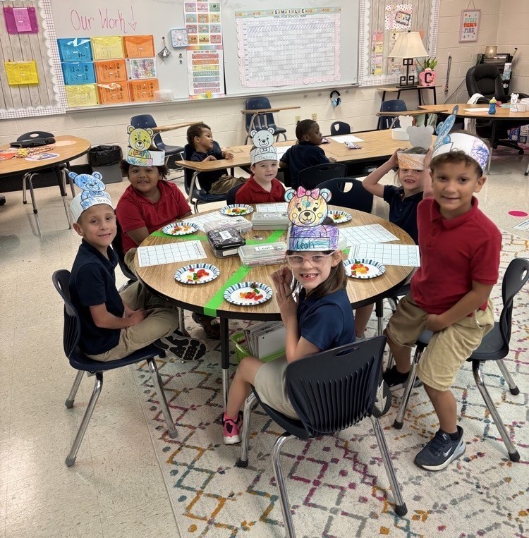 Students sitting around a table, wearing teddy bear hats