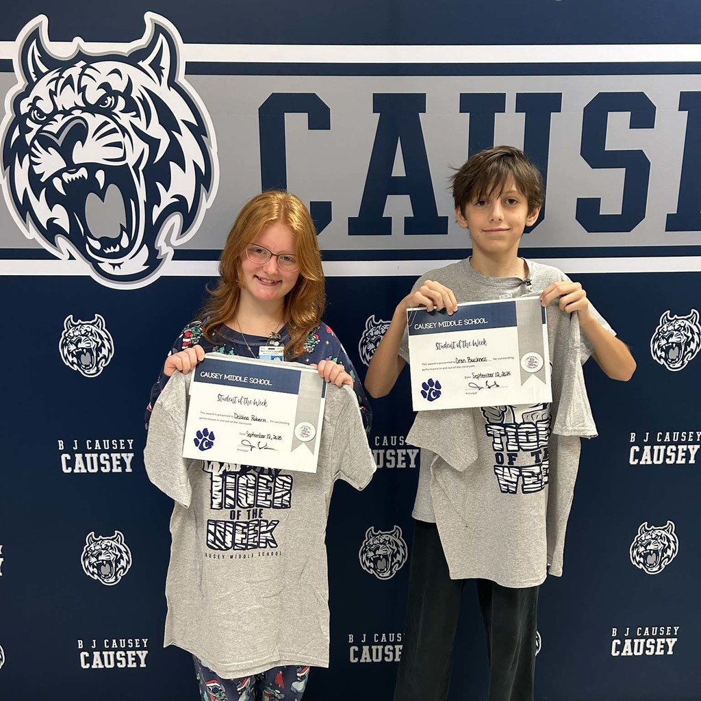 2 students holding a t-shirt and certificate