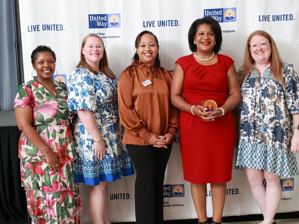 Five women standing in front of a United Way backdrop