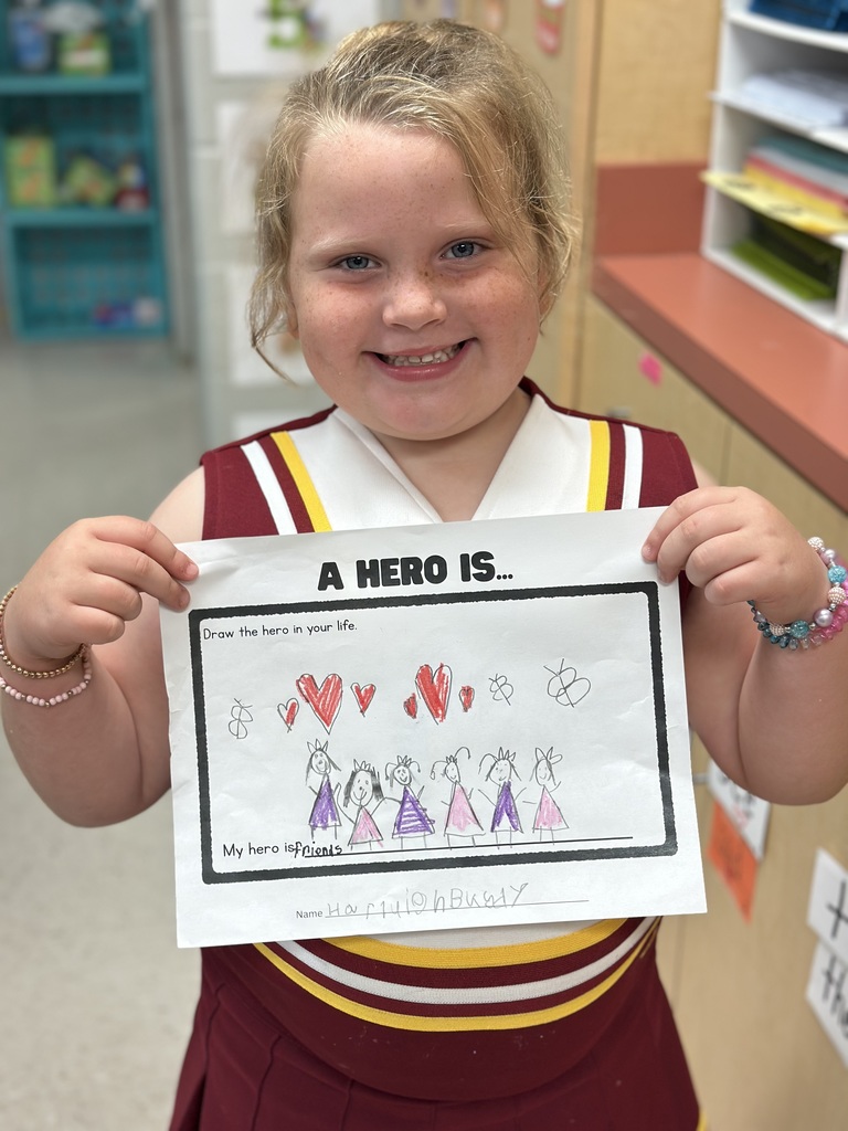 Student holding her paper about A hero is...