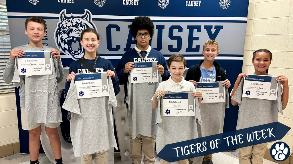 Group of students holding t-shirts and certificates