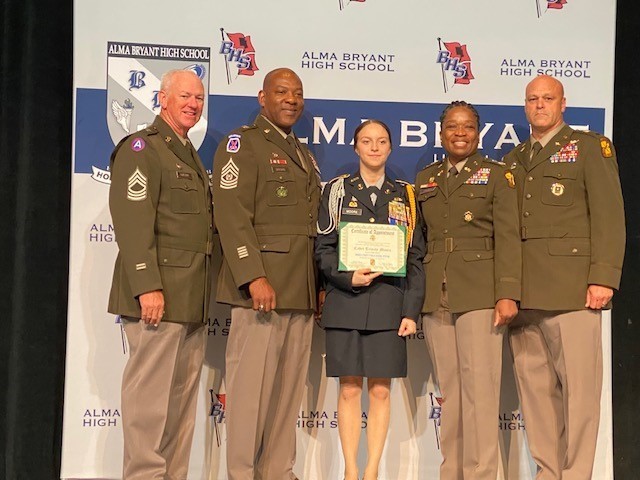 Trinity Moore of Alma Bryant, standing in uniform with four JROTC instructors