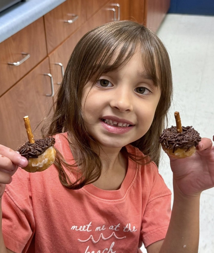 A girl holding two cupcakes