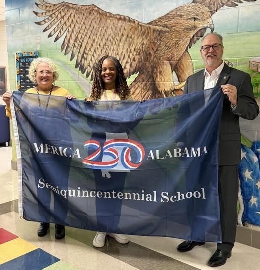 Two educators and a state representative hold a flag
