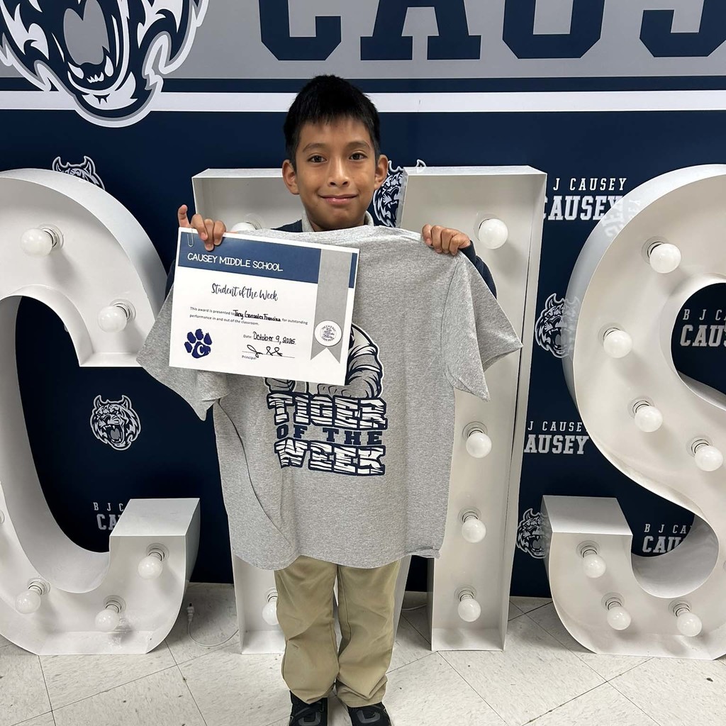 Student holding a certificate and t-shirt