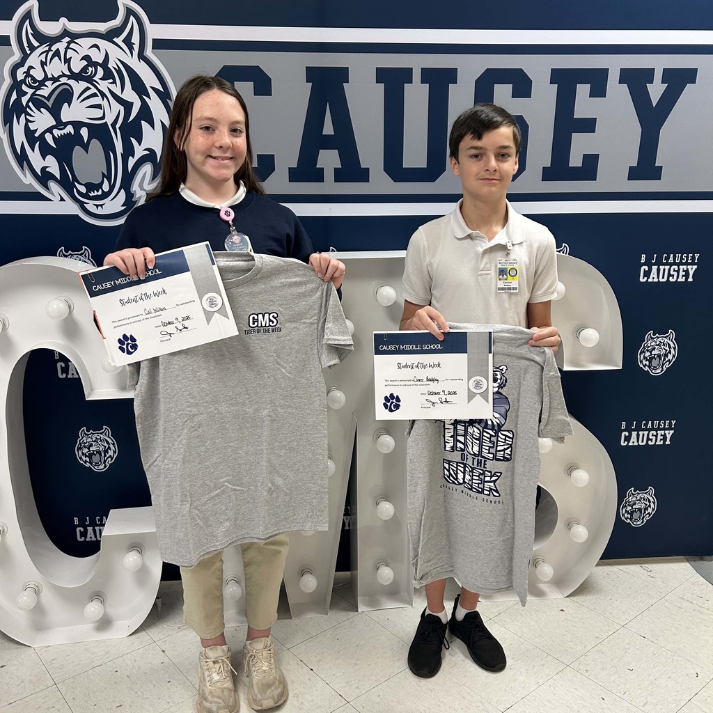 2 students holding up t-shirts and certificates