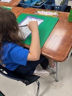 A female student writes predictions on her paper.