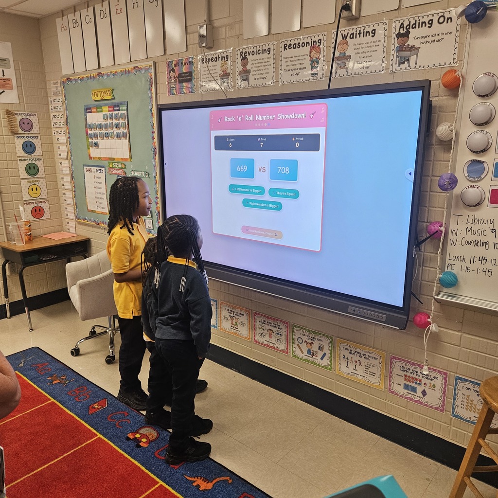 Two students solve a math problem at the Viewsonic board while playing a virtual math game.