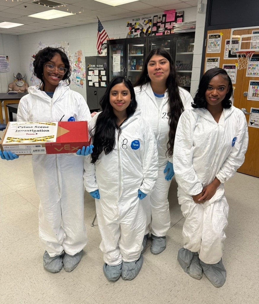Four high school girls in white hazmat suits, with one holding a box of evidence