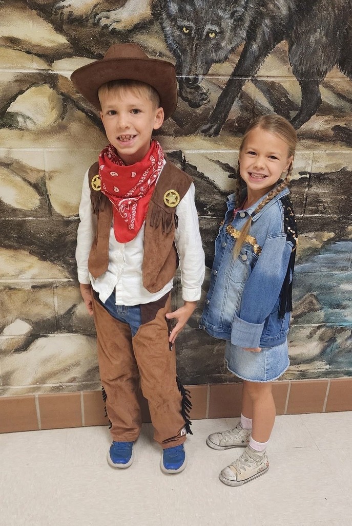 A boy and girl dressed like a cowboy and cowgirl