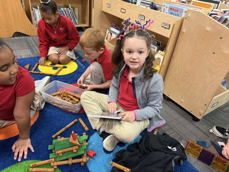 student building a house with Lincoln logs