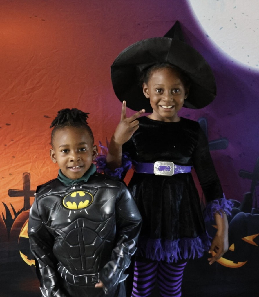 A boy dressed as Batman and a girl dressed as a witch