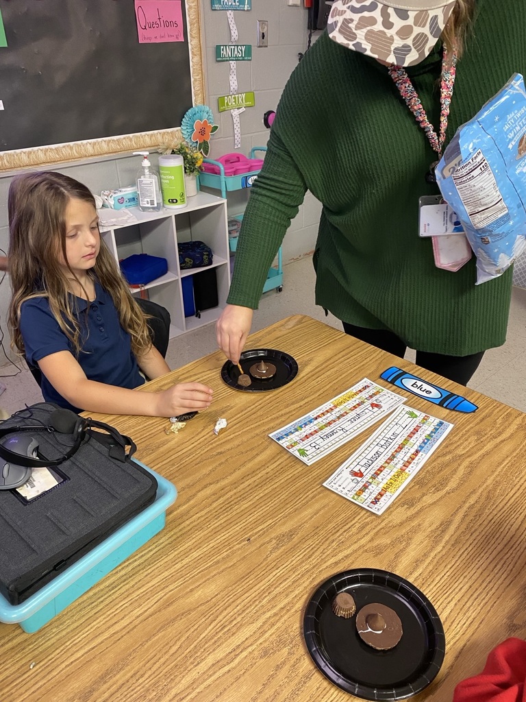 teacher helping a student with a craft