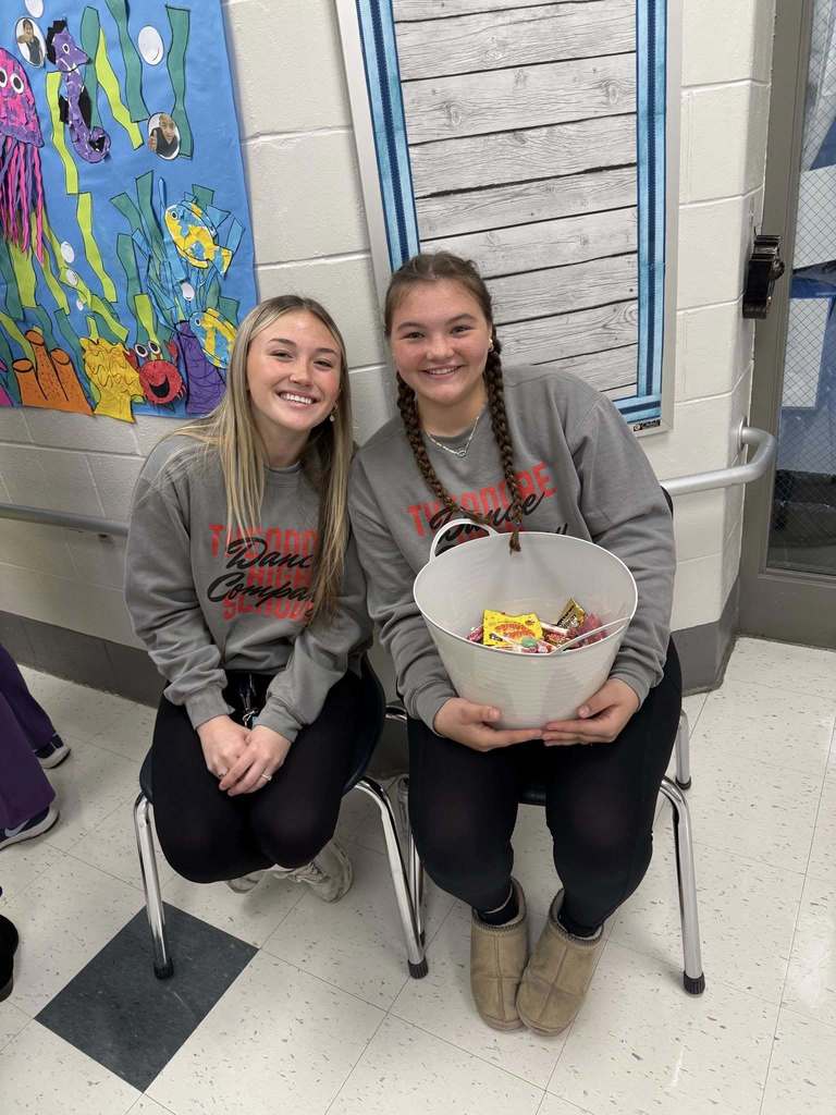 Two girls holding a bucket of candy