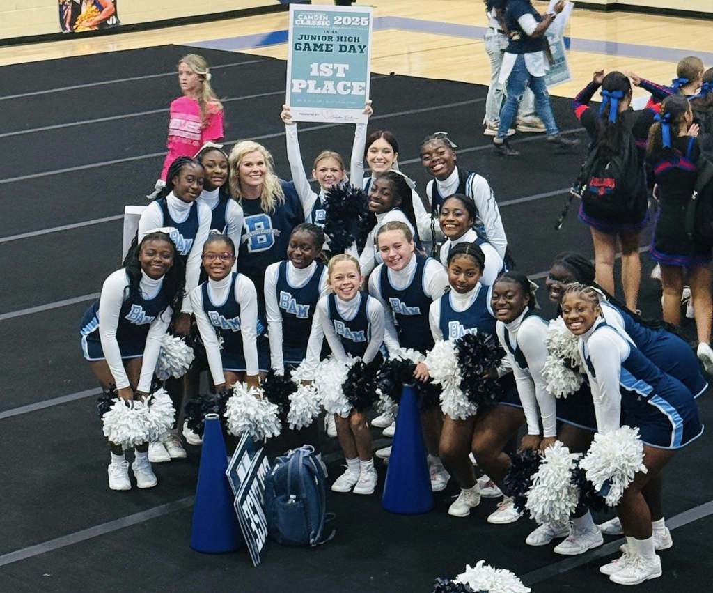 A group of cheerleaders holding a sign that reads "First Place"