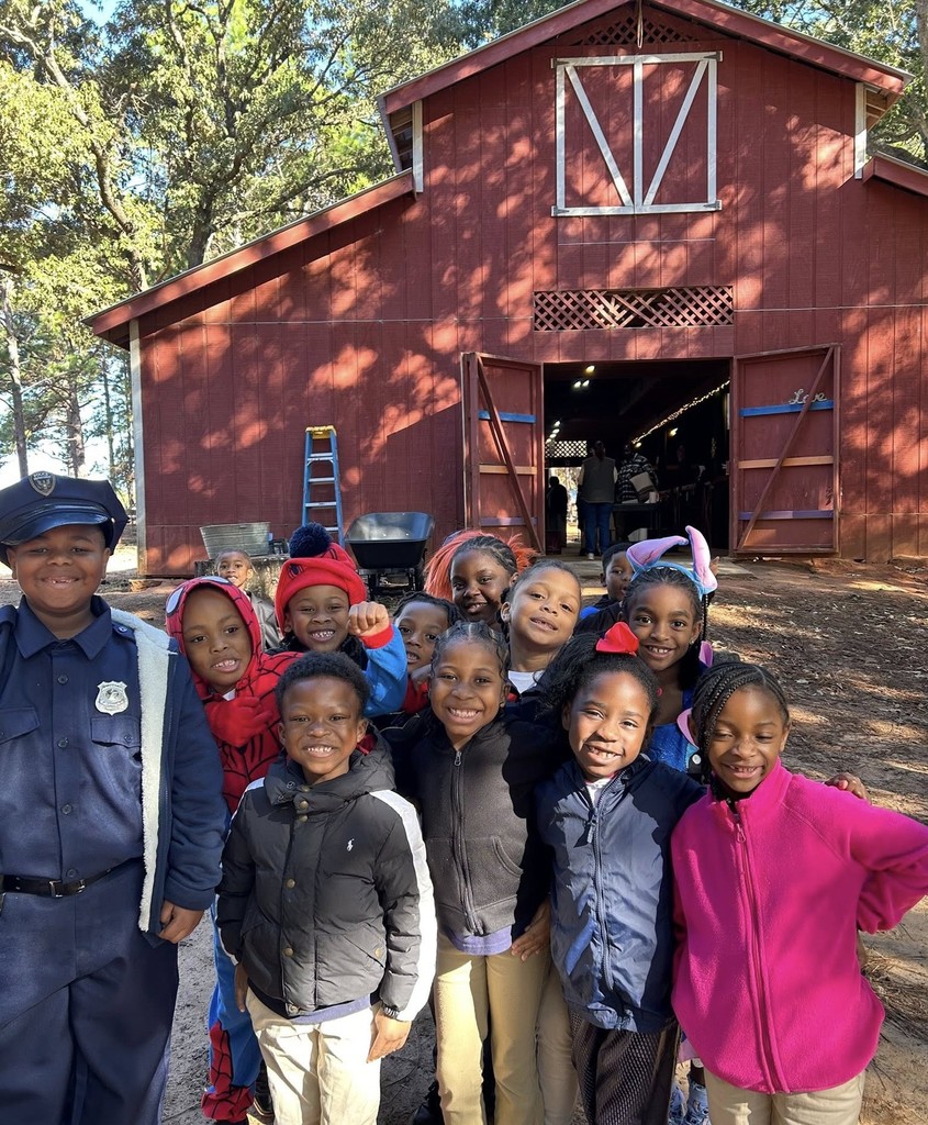 A group of students standing in front of a barn