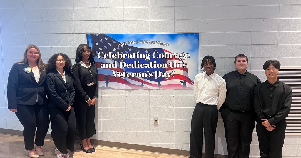 Students in front of a Veterans Day banner
