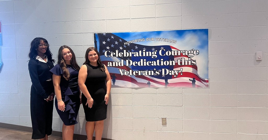 Students in front of a Veterans Day banner