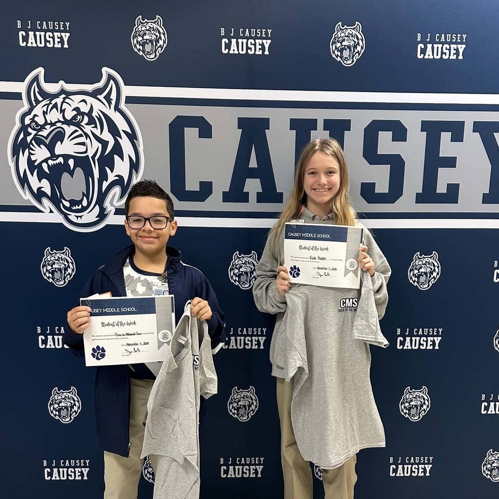 2 students holding up t-shirts and certificates