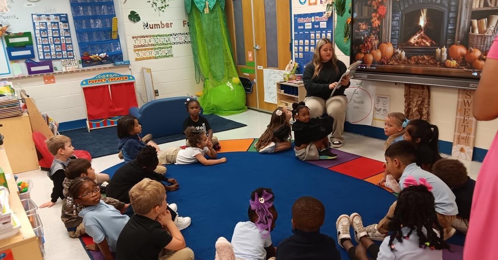 Pre-K students being read to by MGM student