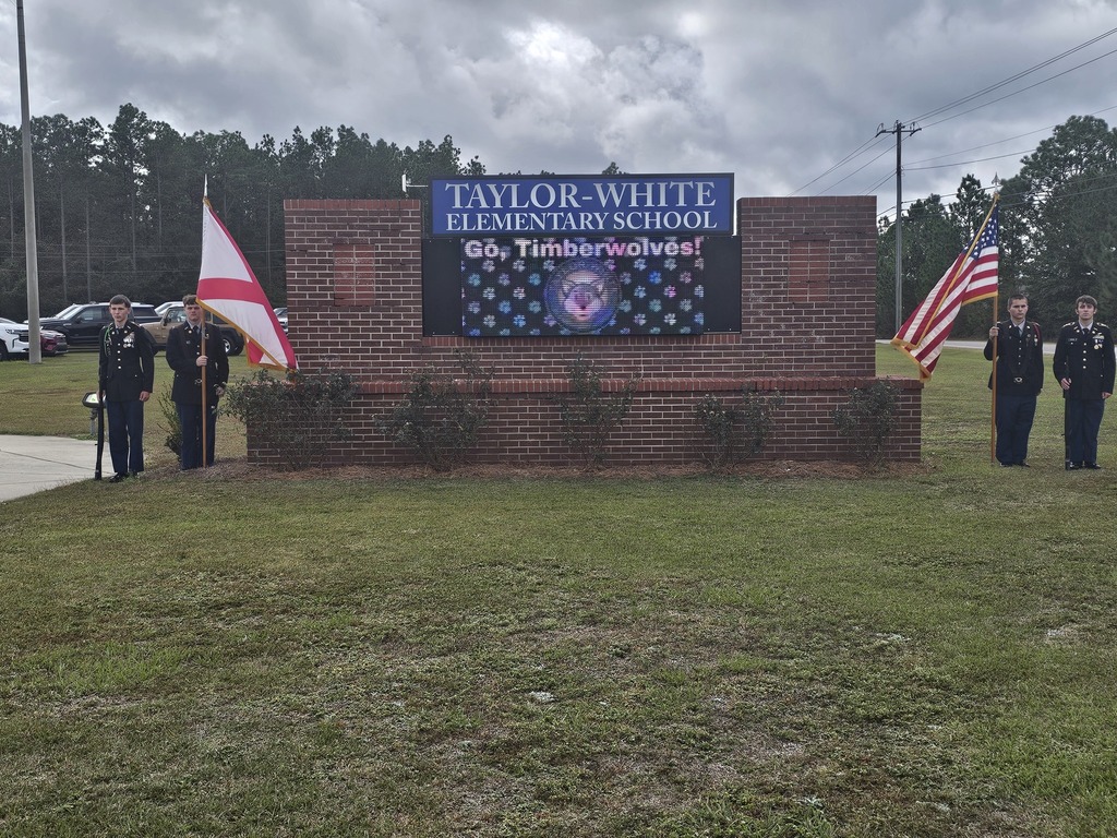 JROTC students by the Taylor-White Elementary Schoo sign