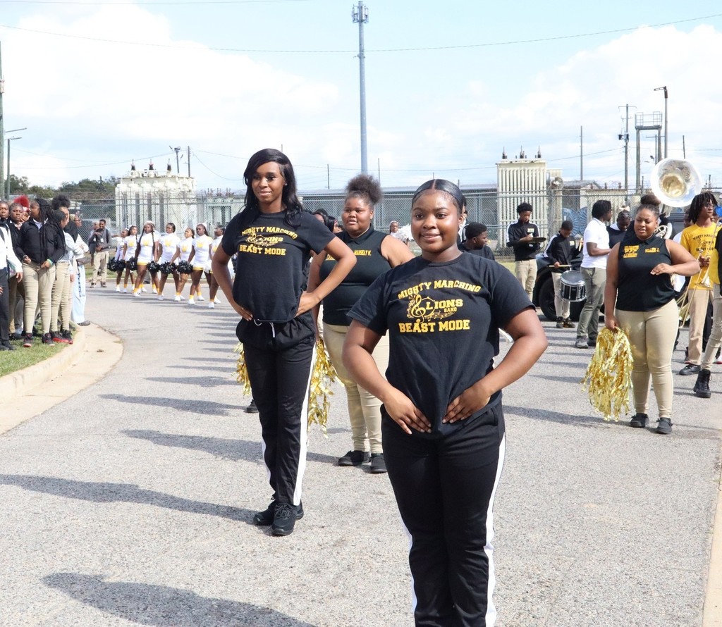Williamson dance team and band members lead the football team toward its bus
