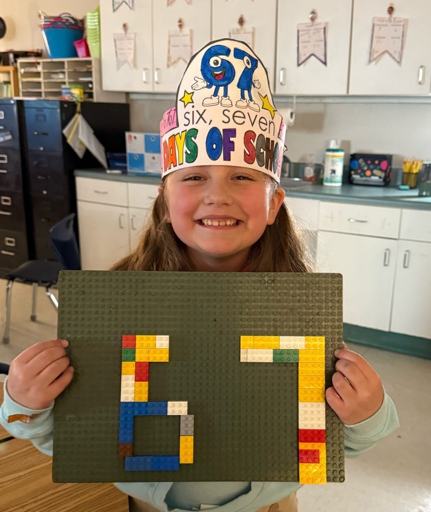 A girl holding legos in the shape of the numbers 6 and 7