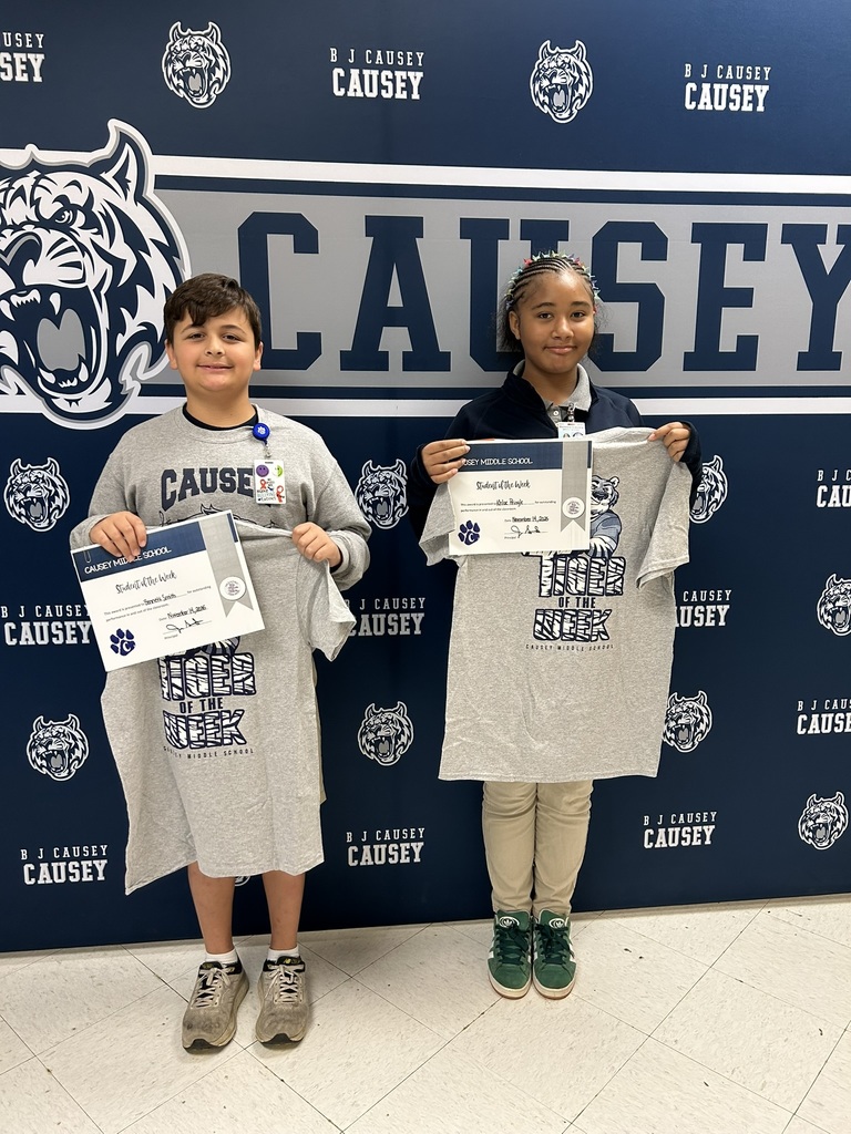2 students holding up t-shirts and certificates