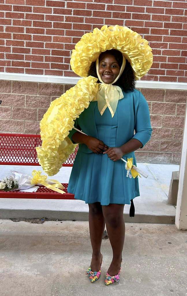 A high school girl with a frilly yellow hat and parasol