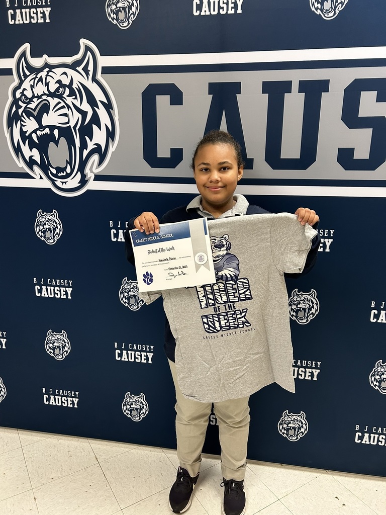 Girl holding up a t-shirt and certificate, Tiger of the Week 11-21