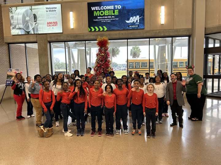 A group of students in red shirts in an airport lobby