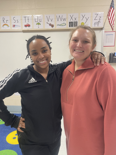 Two teachers standing with each other posing for a picture 