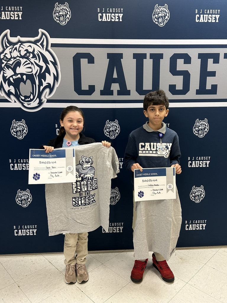2 students holding up t-shirts and certificates
