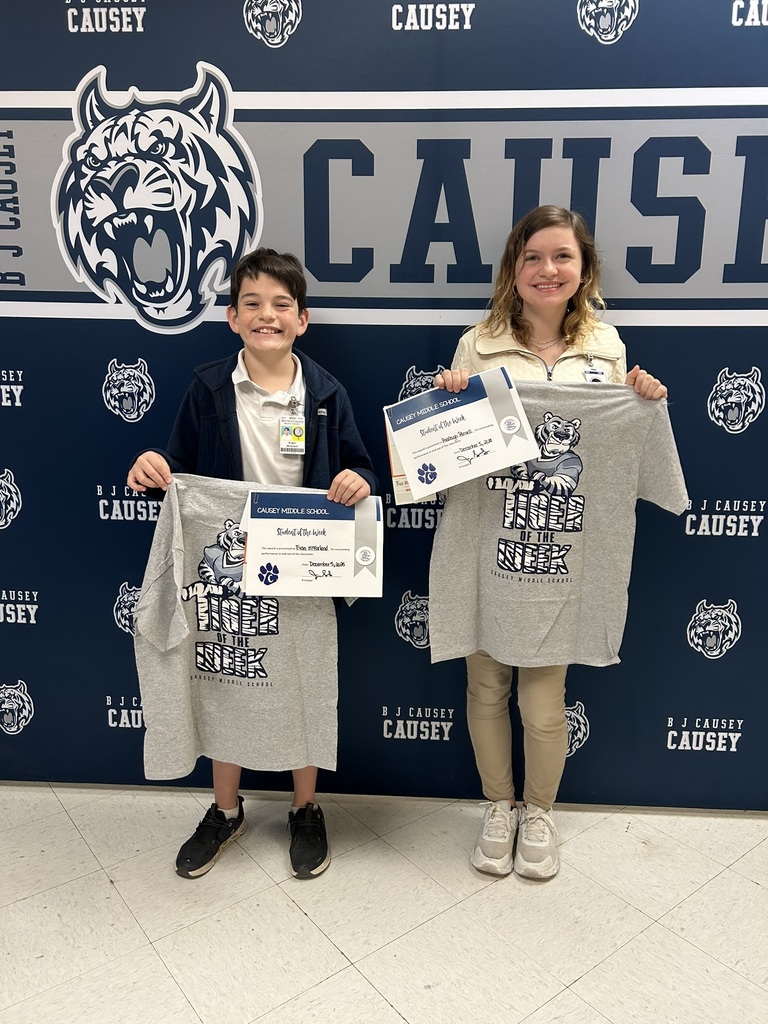 2 students holding up t-shirts and certificates