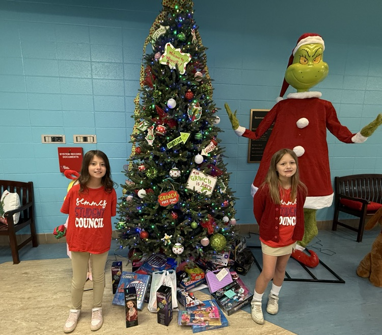 two girls smiling in front of tree