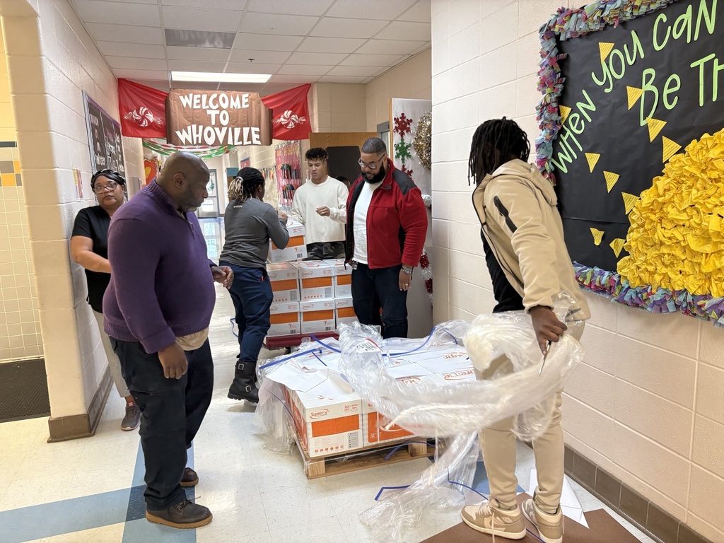 Male staff helping load boxes of paper onto a rolling dolley 