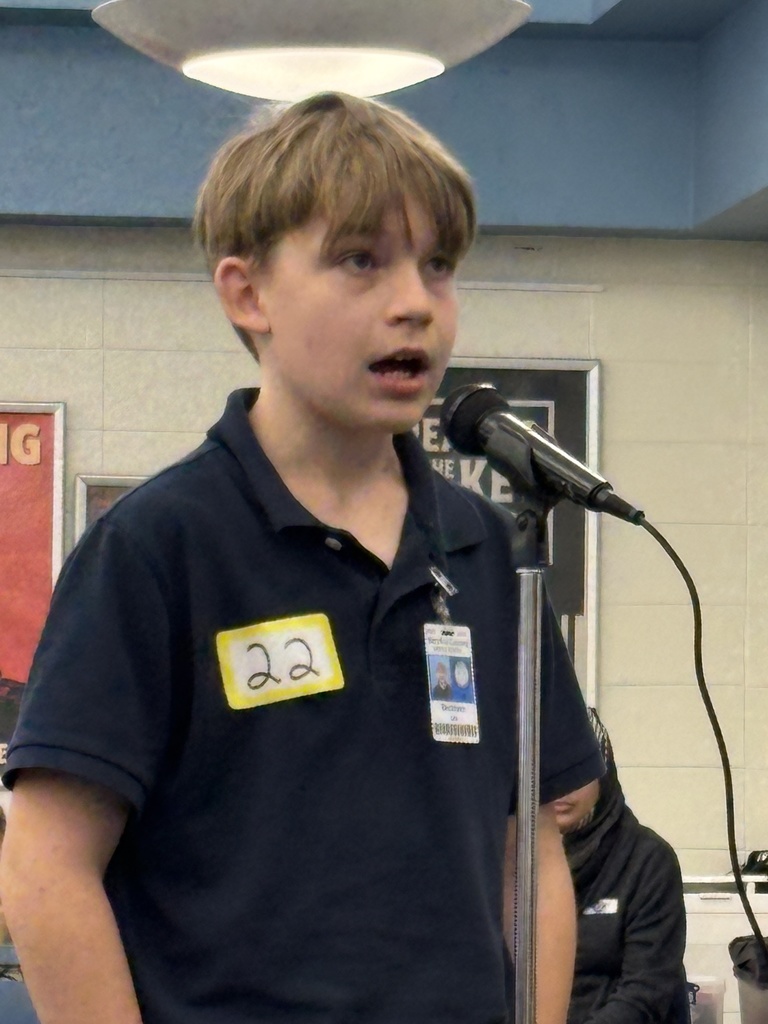 Boy standing at a microphone.