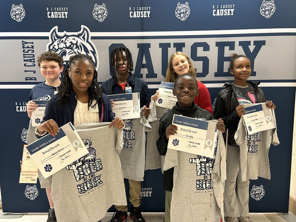 Group of students holding t-shirts and certificate