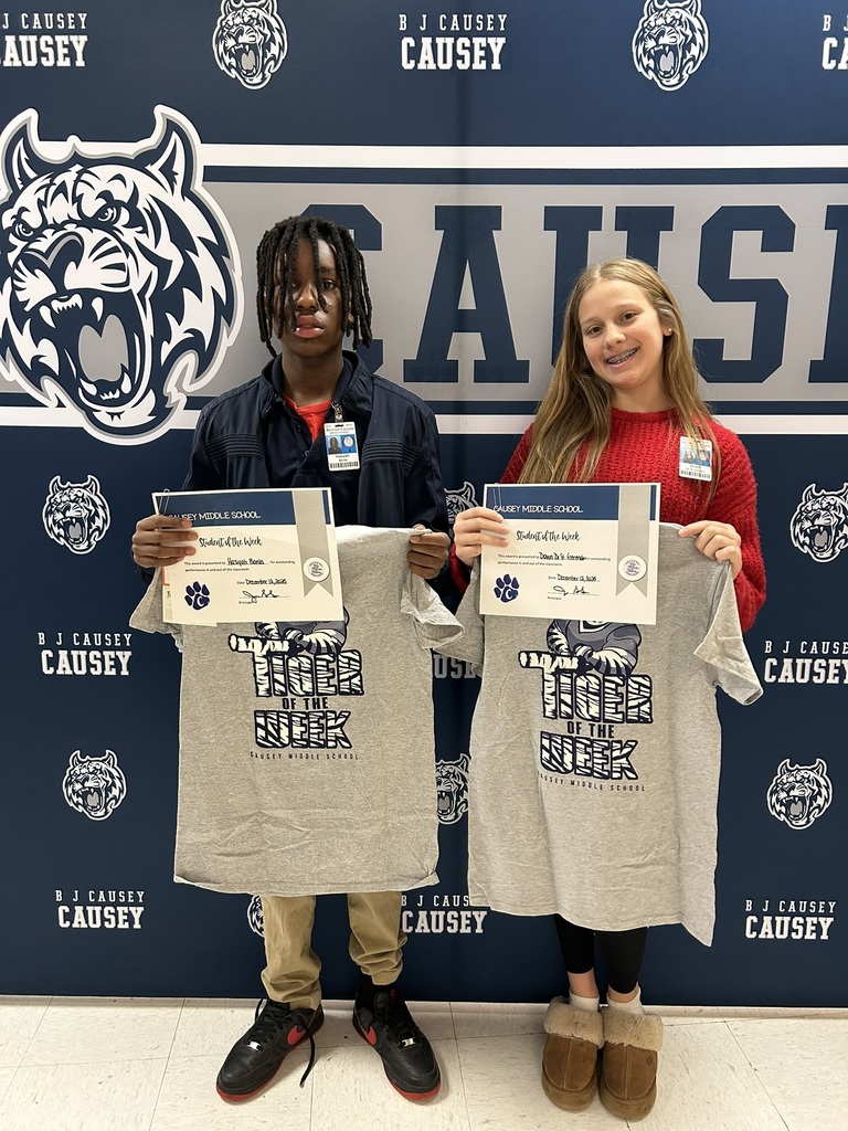 2 students holding up t-shirts and certificates
