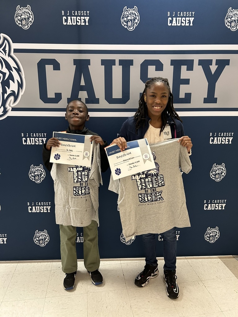 2 students holding up t-shirts and certificates