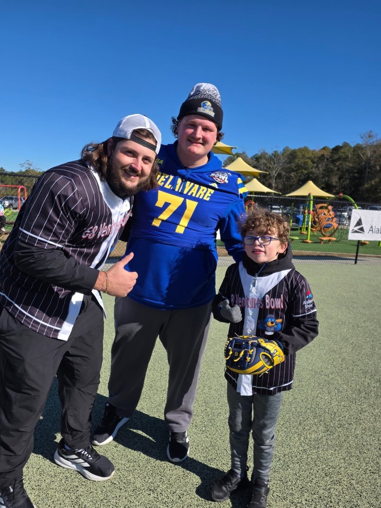 Two Delaware football players pose with a buddy ball player