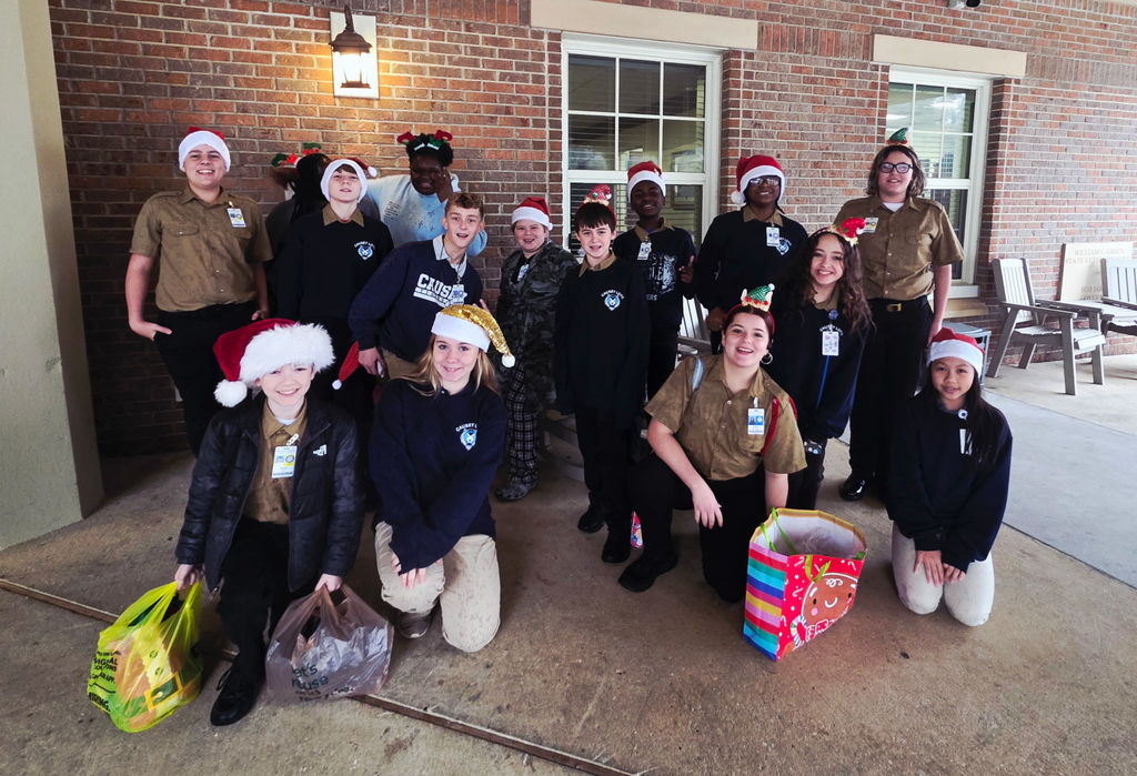 Group of students with bags of goodies and Santa hats