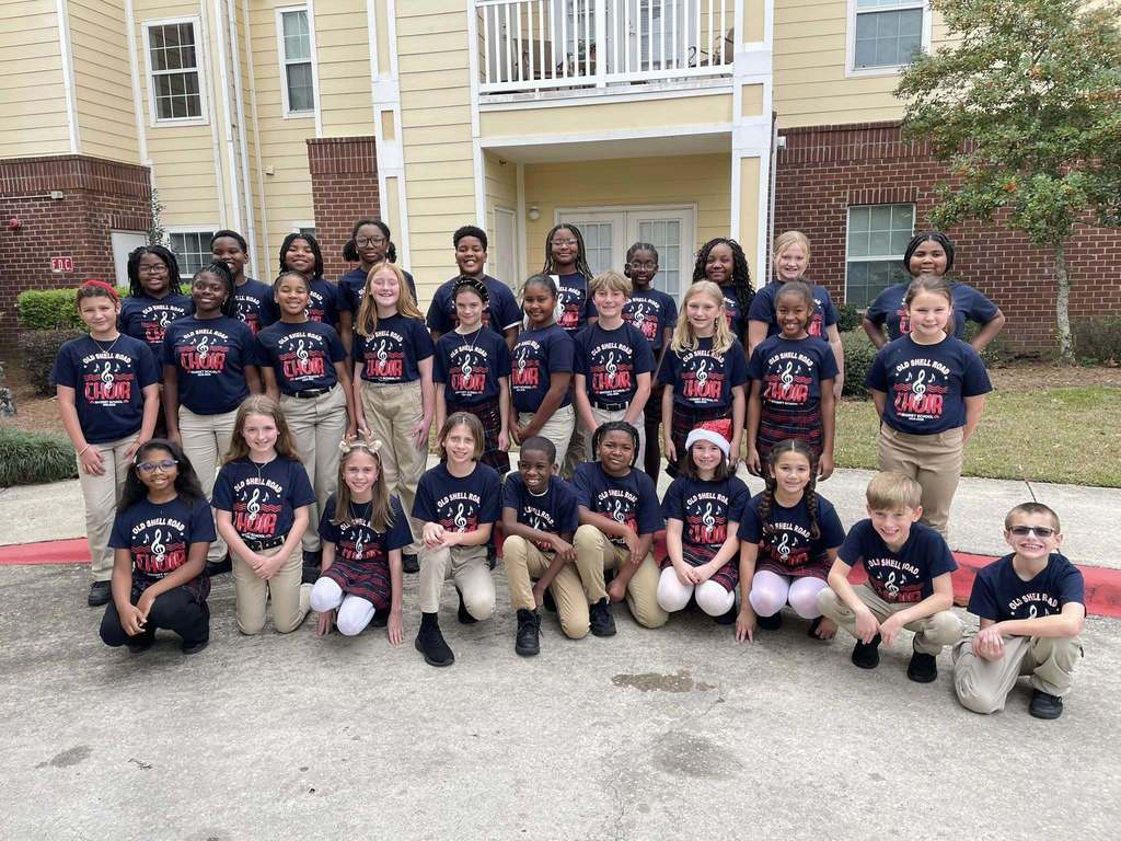 A group of elementary students standing outside an apartment complex