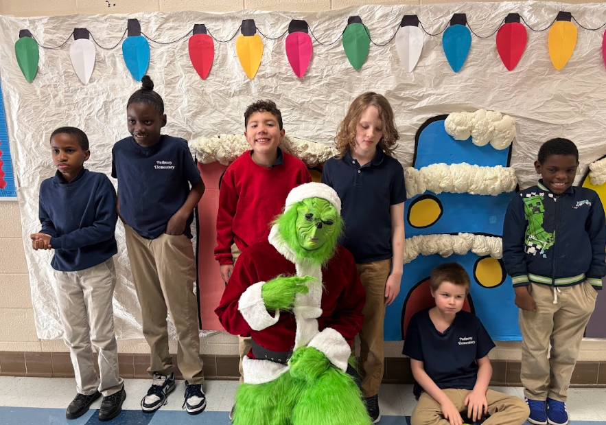 Students standing standing with the Grinch 