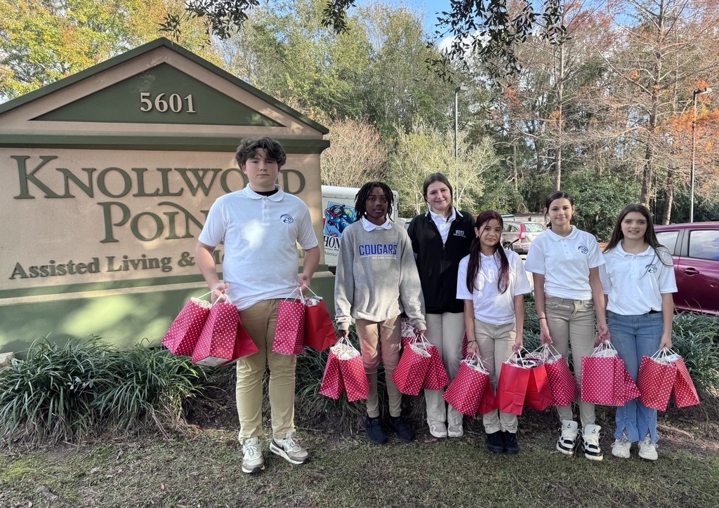 Six students with gift bags, standing outside an assisted living facility