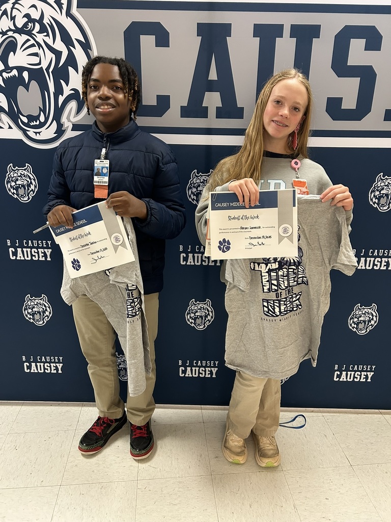 Students holding t-shirts and certificates