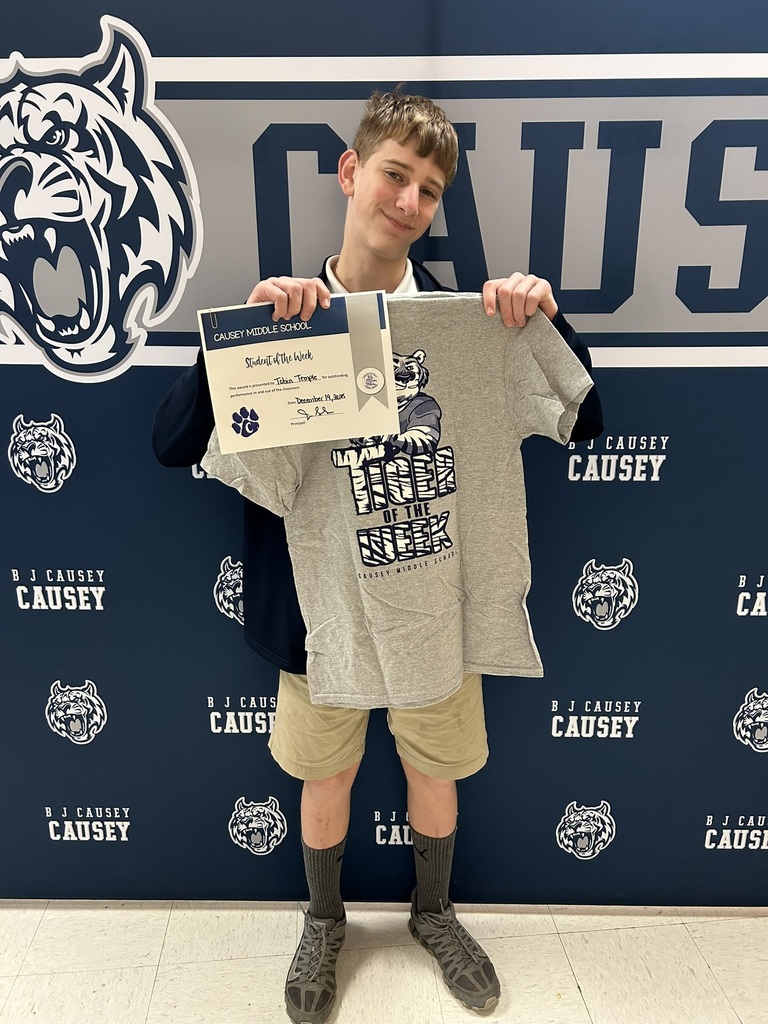 Student holding t-shirts and certificates