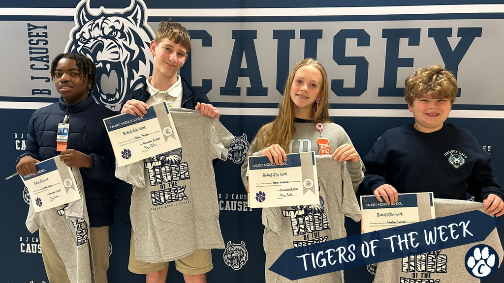 Students holding t-shirts and certificates