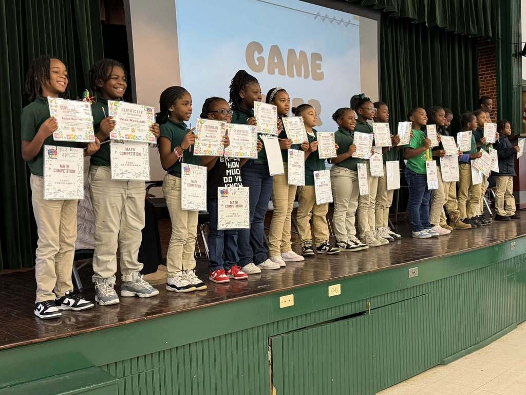 A row of students holding certificates on a stage