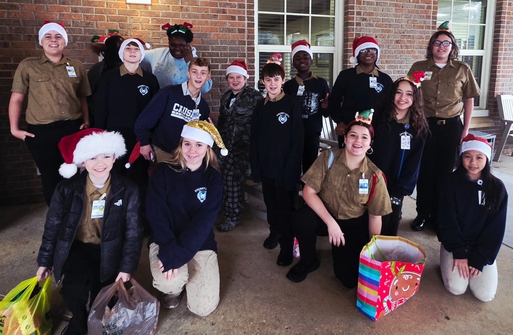 A group of middle school students wearing Santa hats